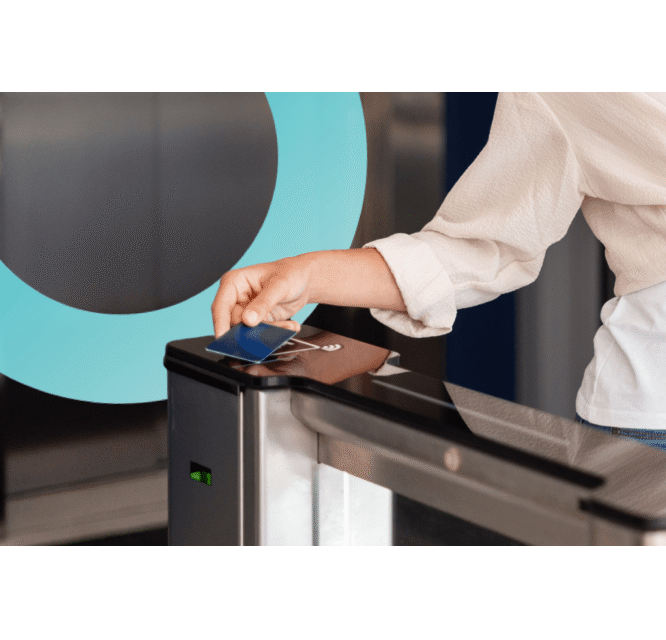 Klubowicz zbliżający kartę dostępu do czytnika na bramce wejściowej w klubie fitness obsługiwanym przez eFitness.